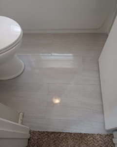 Newly installed tile flooring in a bathroom with a toilet, completed by M7 Remodel & Restoration Inc. in Houston, TX