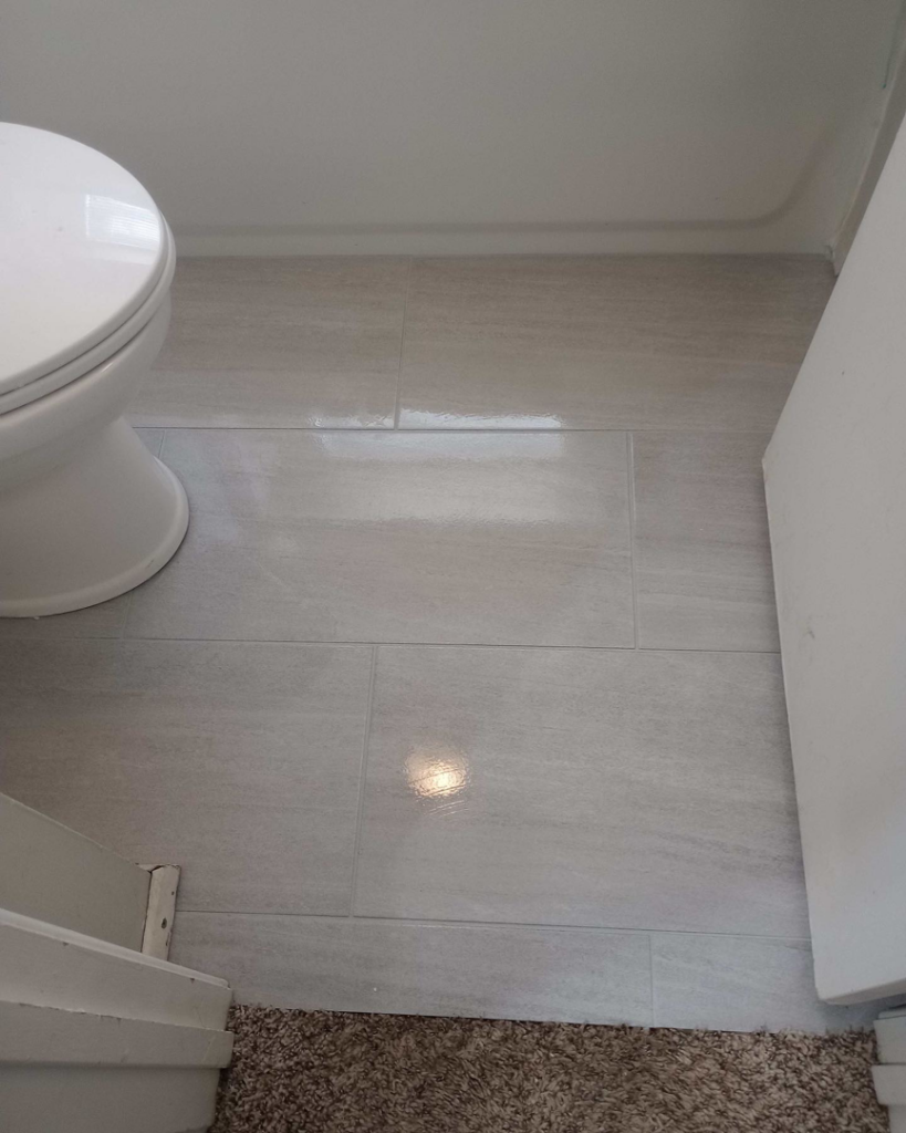 Newly installed tile flooring in a bathroom with a toilet, completed by M7 Remodel & Restoration Inc. in Houston, TX