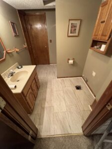 A bathroom renovation in progress with new tile flooring and vanity removed by Gateway Home Services KC LLC in Kansas City, MO.