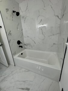 A newly renovated bathroom with marble-look tile and a new tub installed by Garbatini Contracting in Wallingford, CT.