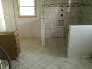 In-progress bathroom renovation showing new floor and shower wall tiling with a built-in niche by Paulus Contracting in Fayetteville, OH