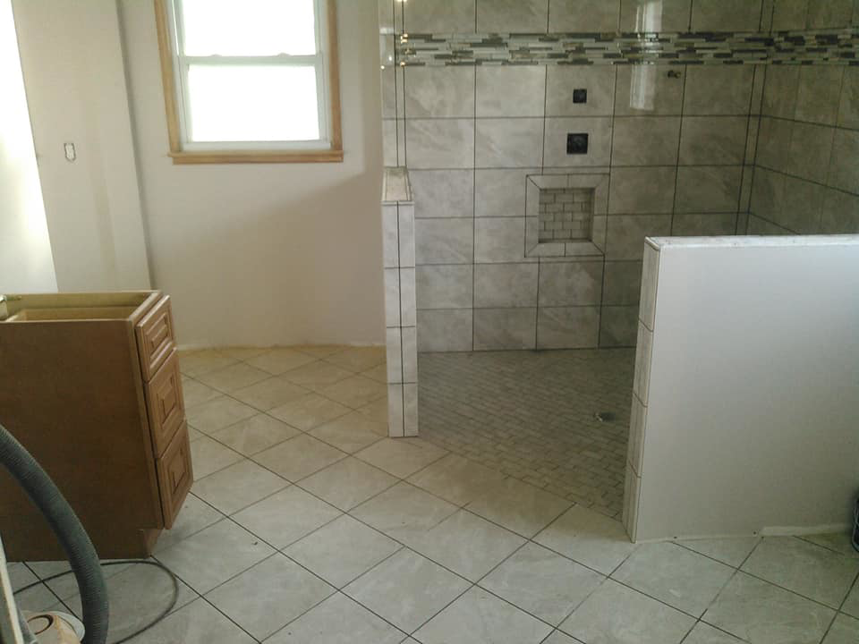In-progress bathroom renovation showing new floor and shower wall tiling with a built-in niche by Paulus Contracting in Fayetteville, OH