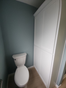A newly installed toilet and tall storage cabinet in a renovated bathroom by Leupitz Contractors Inc in Salem, OR.