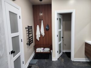 Bathroom with a new towel warmer and wooden accent wall installed by M&M Home Builders, LLC in Richmond, VA.