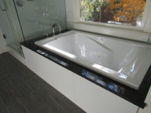 Bathroom renovation featuring a built-in bathtub and glass shower enclosure by KC's Improvement & Construction Co., Inc. in Greensboro, NC
