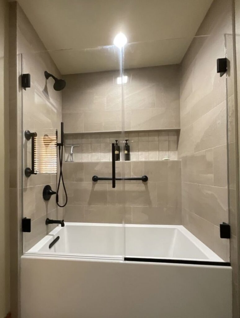 A renovated bathroom with a new tub, glass shower enclosure, and modern tile work by Boisen Remodeling LLC in Appleton, WI.