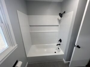 A newly renovated bathroom with a white tub and tiled shower by Smitty's Handyman Service LLC in Mesquite, TX.