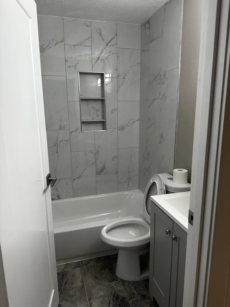 A remodeled bathroom with new tub, shower tile installation, and vanity by A to Z Remodeling llc in Gresham, OR.