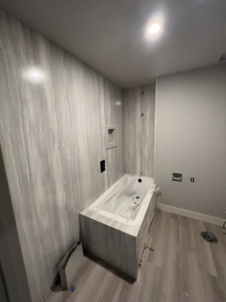 Bathroom remodel in progress with new tub and wall panel installation by Handyman house repairs and remodeling in Provo, UT