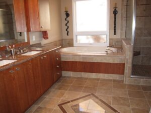 A remodeled bathroom featuring a double vanity, large tub, and tiled shower by Advanced Remodeling Services in Elbert, CO.