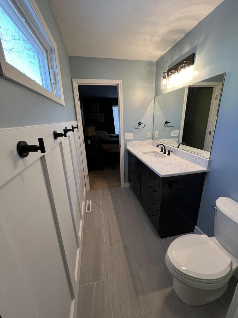 New bathroom vanity, mirror, and toilet installed during a renovation by Roempagel Renovations LLC in South Bend, IN.