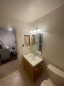 An old bathroom vanity with exposed wall and electrical, ready for renovation by Done Right Construction in Johnston, IA.