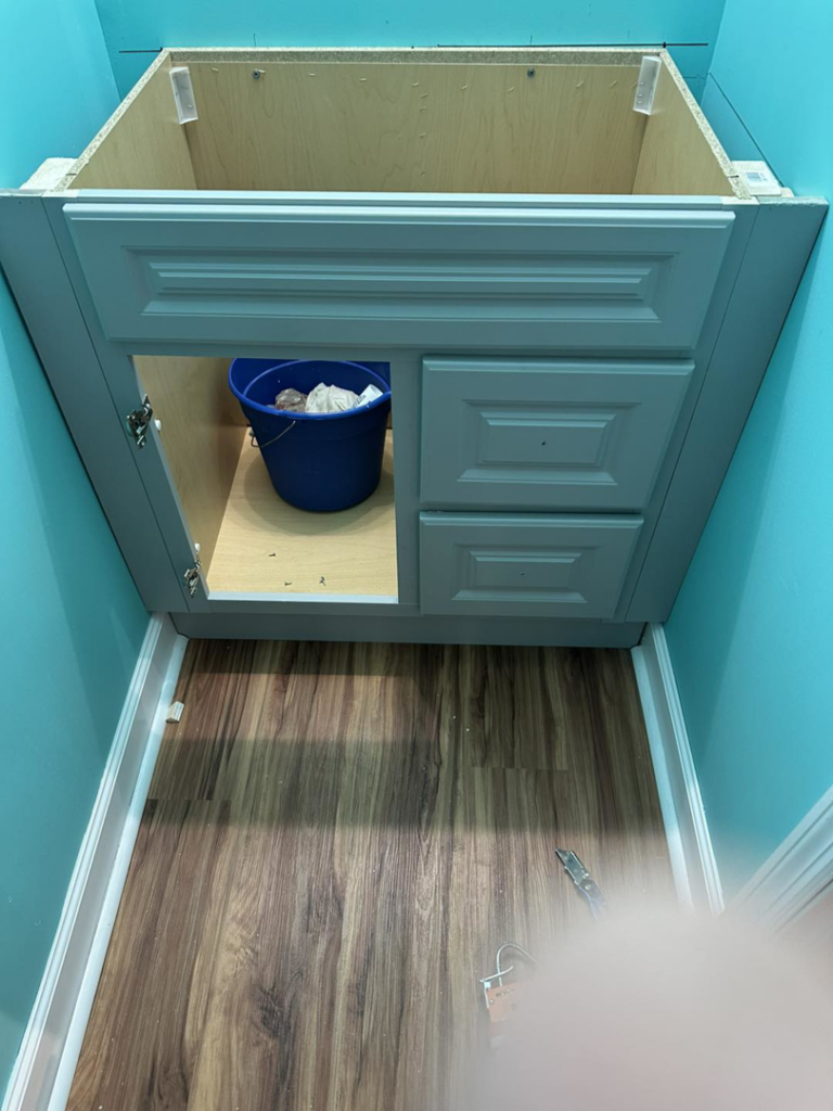 A bathroom vanity cabinet installed and awaiting countertop and plumbing by Quality Home Maintenance Services LLC in Raleigh, NC