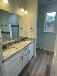 Newly installed bathroom vanity with double sinks, faucets, mirror, and lights by Govco Builders, Inc. in Newport News, VA