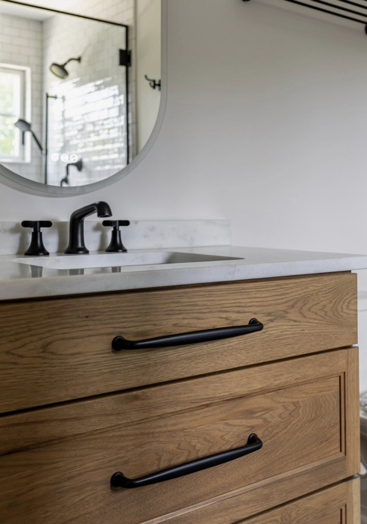 Close-up of a newly installed bathroom vanity with a wooden cabinet and black faucet by Kyle Build in Chattanooga, TN.