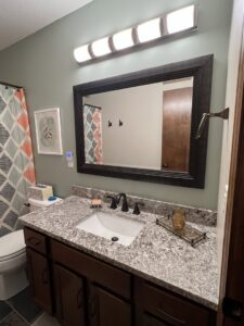 Newly installed bathroom vanity, faucet, mirror, and light fixture by Med City Handy Ma'am in Rochester, MN
