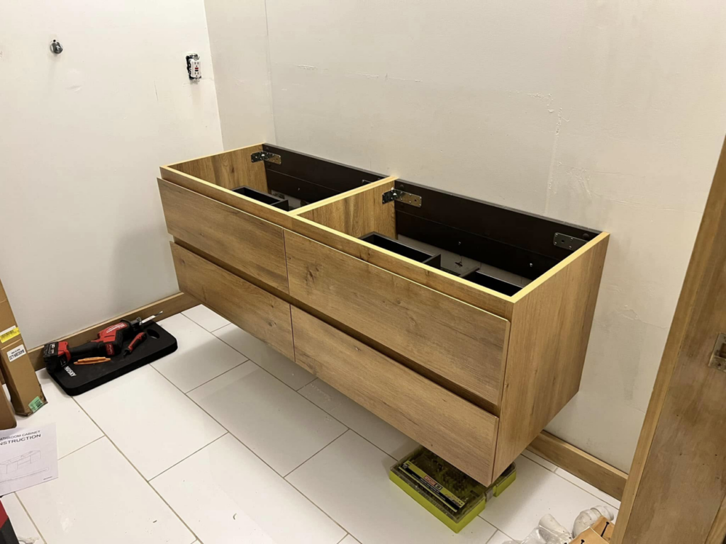 A new floating bathroom vanity cabinet being installed by Armbruster General Contracting in Cincinnati, OH.