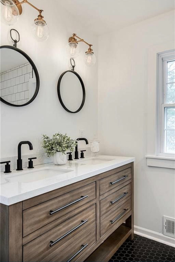 A modern bathroom featuring a double vanity with black fixtures and round mirrors, installed by Dogwood Renovation & Design, LLC in Kansas City, MO.