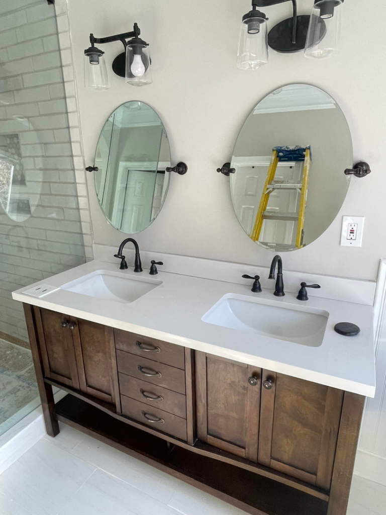 Installation of a new bathroom vanity with double sinks, mirrors, and light fixtures by Stonehedge Construction in Buford, GA