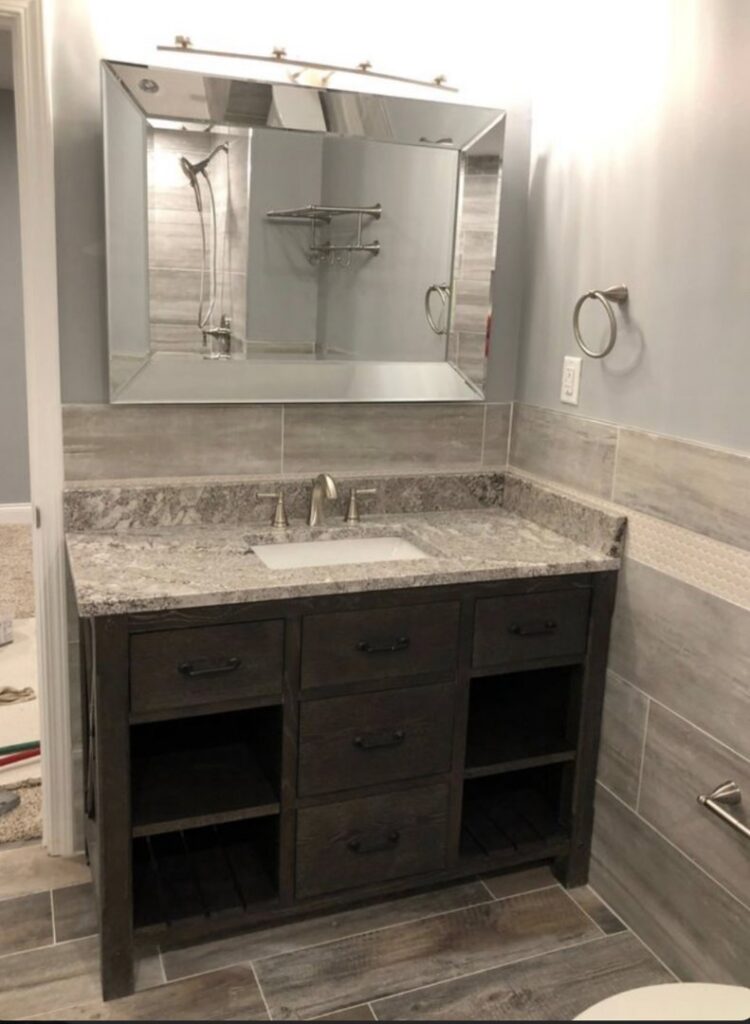 A newly installed bathroom vanity with granite countertop and large mirror by Grizzly Renovations in Naperville, IL