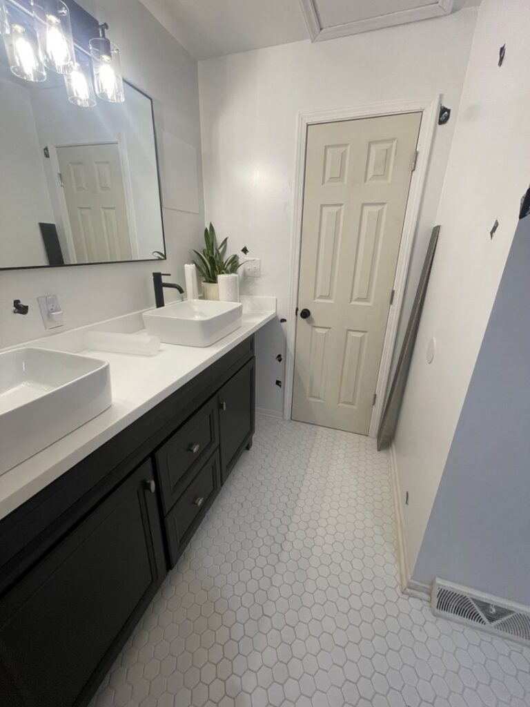 A newly installed double bathroom vanity with vessel sinks and hexagon tile flooring by Donaldson & Company Construction in Charlotte, NC.