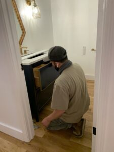 A worker installing a new bathroom vanity for Kennyman The Handyman Inc. in San Francisco, CA
