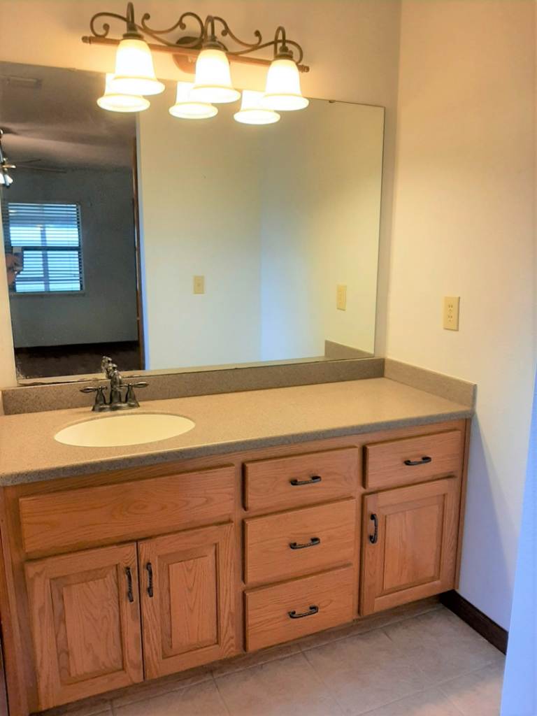 A newly installed bathroom vanity and mirror by Knupper Properties & Knupper Homes in Clermont, FL.