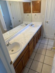 A newly installed bathroom vanity with double sinks and a large mirror by Lay's Remodeling LLC in El Paso, TX