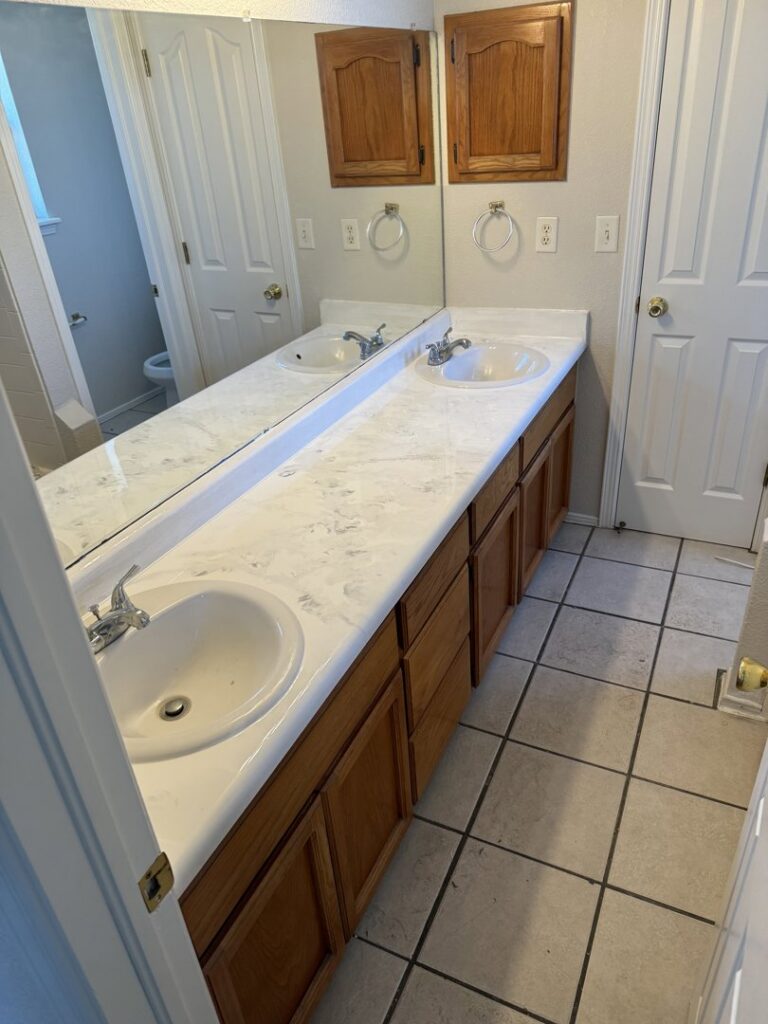 A newly installed bathroom vanity with double sinks and a large mirror by Lay's Remodeling LLC in El Paso, TX