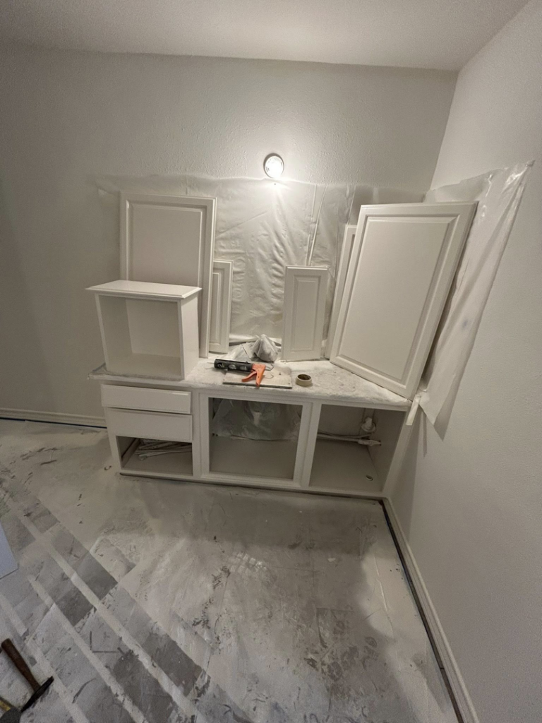 Bathroom vanity installation in progress with new cabinets and protected floor by Michael South Home Renovations in Fort Worth, TX.