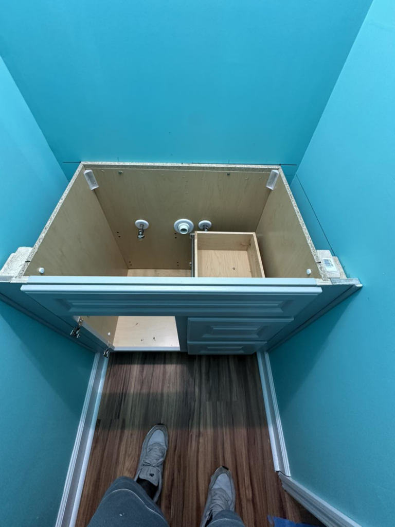 An unfinished bathroom vanity installation with exposed plumbing by Quality Home Maintenance Services LLC in Raleigh, NC