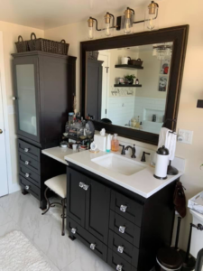 A newly installed bathroom vanity with a sink, mirror, and modern light fixture by Solis and Son Construction in Denver, CO.