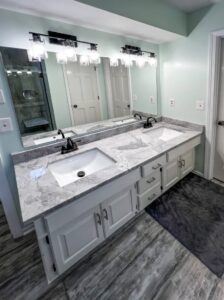 New bathroom vanity with double sinks and modern light fixtures installed by Thrive Homes, LLC in Olathe, KS.