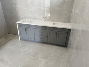 Bathroom vanity installation with double sinks, cabinets, and tiled walls by C.A Tano Construction & Appliances Cgc1531664 in Cape Coral, FL.