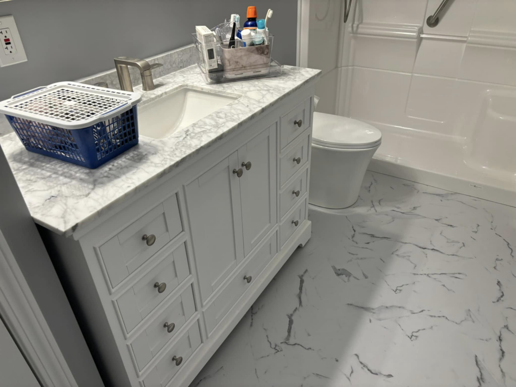 A newly installed bathroom vanity with a marble countertop by Top Gunn Family Construction in Truxton, MO.