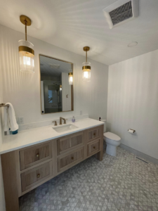 A modern bathroom with a new vanity, mirror, and pendant lights installed by Abbott Construction LLC in Boxford, MA.