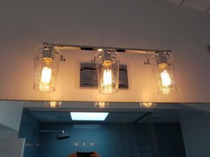 A stylish three-light vanity fixture installed above a bathroom mirror by Barry's Handyman Service in San Diego, CA.