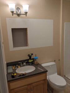 Bathroom vanity area with a wall cut-out for medicine cabinet installation by MB&E Home Improvement in Augusta, ME.