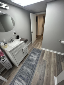 Bathroom with new vanity, sink, mirror, and LVP flooring installed by Kings Handyman Services in Dallas, TX