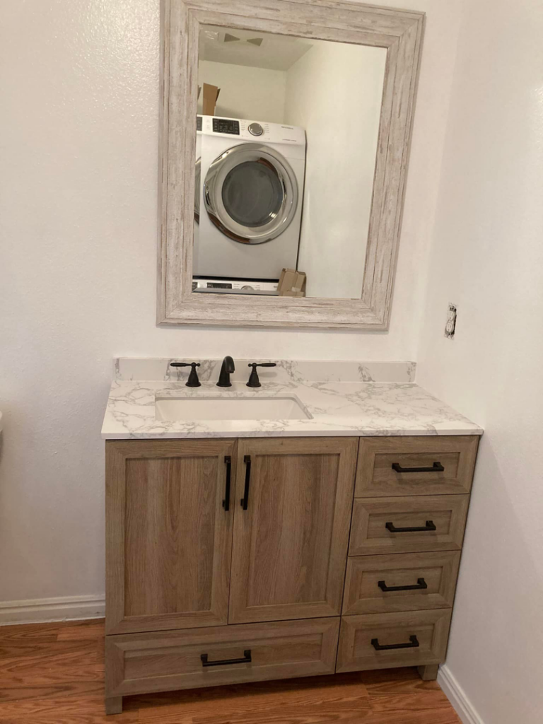 Newly installed bathroom vanity with sink, faucet, and mirror, showcasing handyman fixture installation by JMY Construction in Meridian, ID.