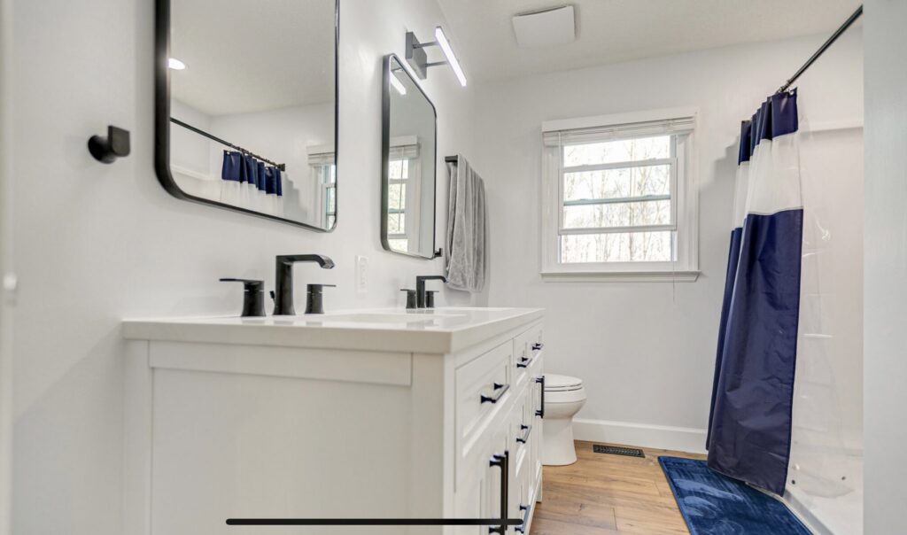 A modern bathroom with a new double vanity and mirrors installed by L12 Construction LLC in Oshkosh, WI.
