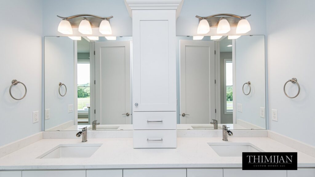 A double vanity bathroom with white cabinets, dual sinks, and mirrors, installed by Thimijan Custom Homes LLC in Rochester, MN