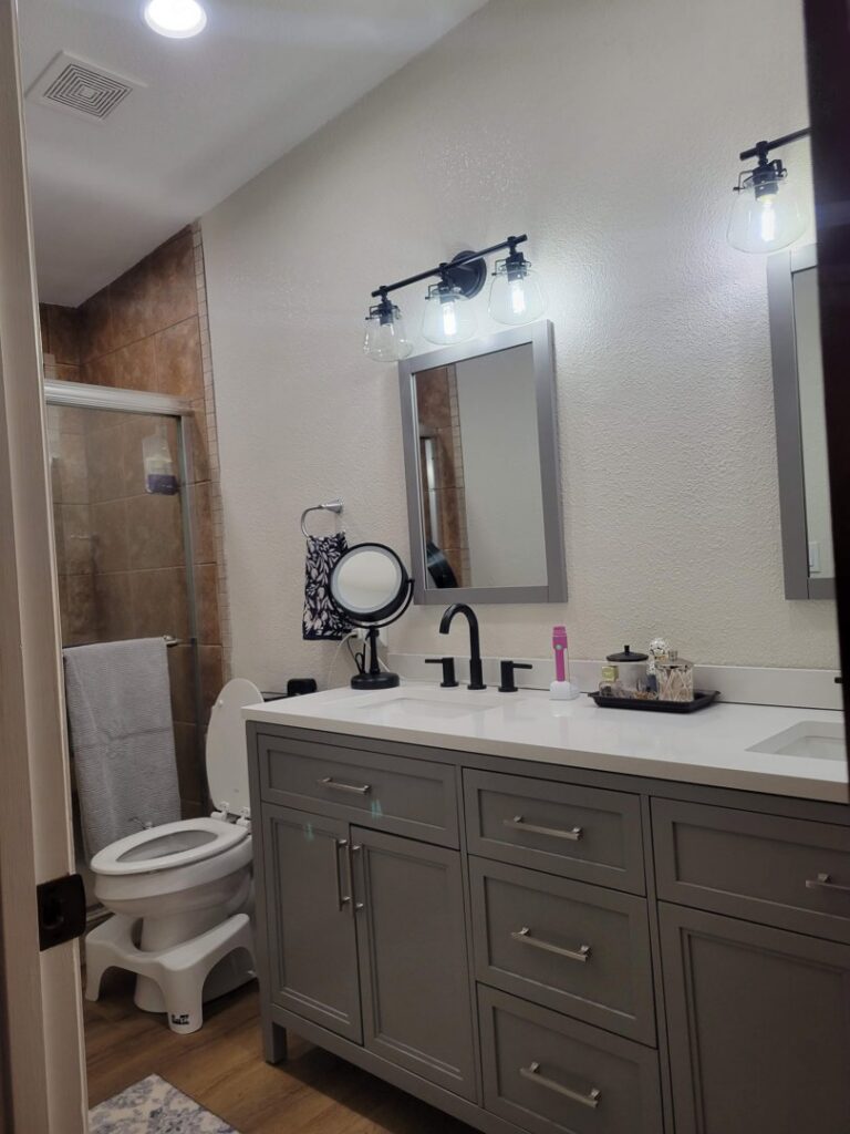 A newly installed bathroom vanity, mirrors, and lighting fixtures by McCarran Handyman Services in Boulder City, NV.
