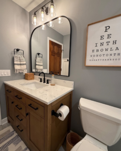 A newly installed bathroom vanity with a modern mirror and light fixture by Valley Wide Design & Build in San Tan Valley, AZ.