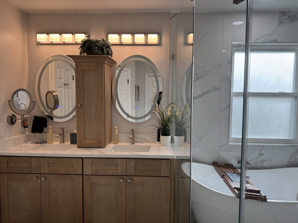 Custom bathroom vanity with oval mirrors and modern lighting fixtures by Amazing Spaces 21 in Orlando, FL