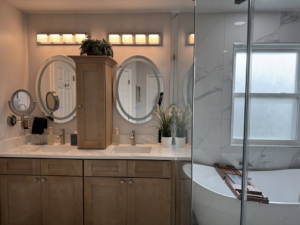 Custom bathroom vanity with oval mirrors and modern lighting fixtures by Amazing Spaces 21 in Orlando, FL