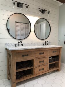 A renovated bathroom featuring a double wooden vanity and shiplap walls by Florida Palm Construction, Inc. in Davie, FL