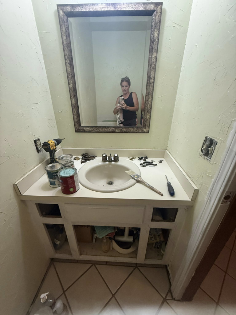 Bathroom vanity renovation in progress with tools, paint, and sink installation by Duane Moss Painting in Oklahoma City, OK.