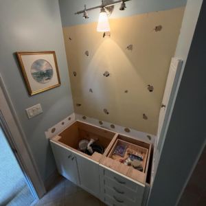 A bathroom vanity area undergoing renovation with the countertop removed, showing exposed plumbing, by Kangas Contracting LLC in Chesapeake, VA.