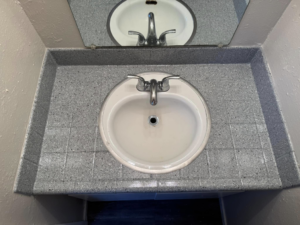 A newly resurfaced grey speckled bathroom vanity and sink by That Resurfacing Guy LLC in Oklahoma City, OK.